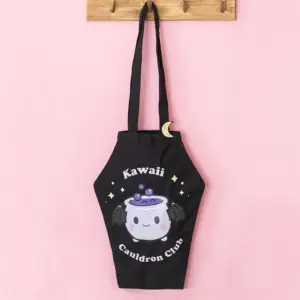 Bolso tote ataúd Kawaii Cauldron Club colgado en una escena rosa