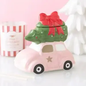 Quemador de aceite con coche rosa en una escena navideña rosa