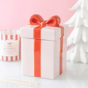 Quemador de aceite Regalo rosa cerrado en una escena navideña rosa