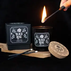 Vela Black Rose Twilight Blush encendida en una escena oscura
