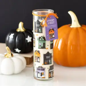 Vela de canela y calabaza Spooky Street en una escena de Halloween con calabazas